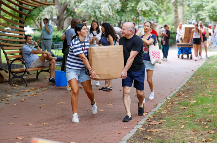 People carry a large box, at a college move in